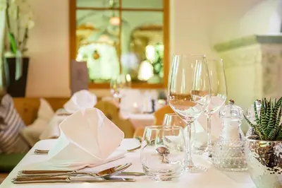 a table with wine glasses and napkins on it at Hotel Erika in Braies