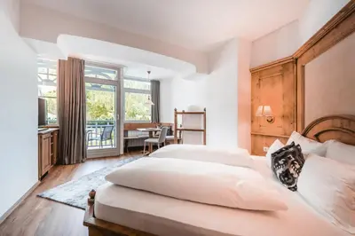 a bedroom with two beds and a table and a window at Hotel Erika in Braies