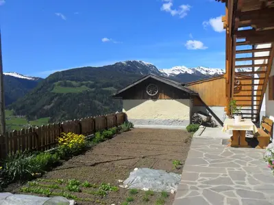 a backyard with a fence and mountains in the background at Maurerhof Telves in Racines