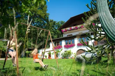 two girls playing on a swing in a yard at Gasthof Wieser in Appiano sulla Strada del Vino