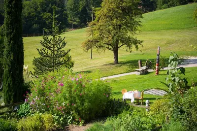 a park with a table and chairs in the grass at Gasthof Wieser in Appiano sulla Strada del Vino