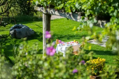 a picnic table in the grass in a garden at Gasthof Wieser in Appiano sulla Strada del Vino