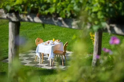 a table with a white table cloth and chairs at Gasthof Wieser in Appiano sulla Strada del Vino