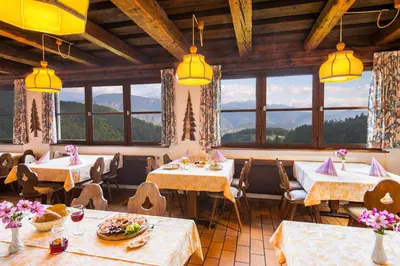 a restaurant with tables and chairs and windows at Gasthof Wieser in Appiano sulla Strada del Vino