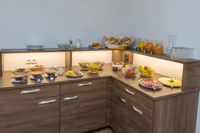 a kitchen with many bowls of food on a counter at Gasthof Falkenstein in Naturno