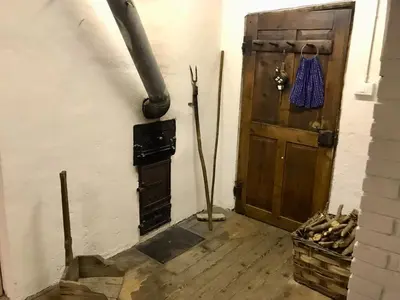 a room with a wood stove and a door at Knottn Hüttl, St. Pankraz/Ulten, Nähe Meran in San Pancrazio dʼUltimo