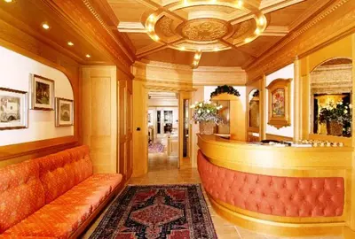 a lobby with a bar with a couch and a rug at Hotel Europa in Moena