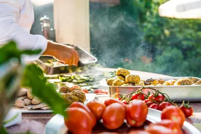 a chef preparing food on a table with tomatoes at Hotel Verena in Lana