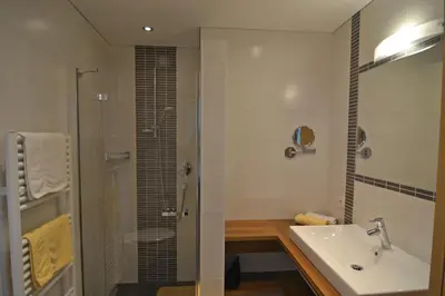 a bathroom with a sink and a glass shower at Residence Talblick in San Leonardo in Passiria