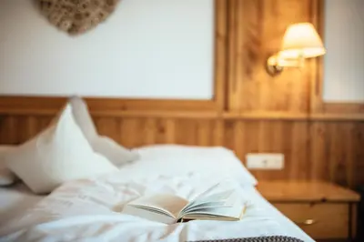 a book sitting on top of a bed at Tirolerhof in San Leonardo in Passiria