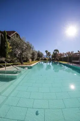 a large swimming pool with a blue at Felderer Boutiquehotel B&B in Caldaro