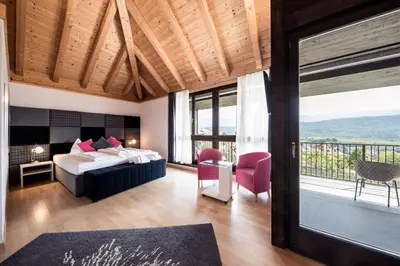 a hotel room with a bed and a balcony at Felderer Boutiquehotel B&B in Caldaro