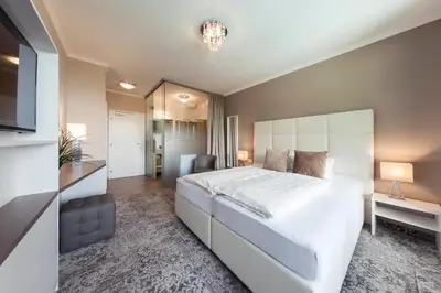 a bedroom with a large white bed and a desk at Felderer Boutiquehotel B&B in Caldaro