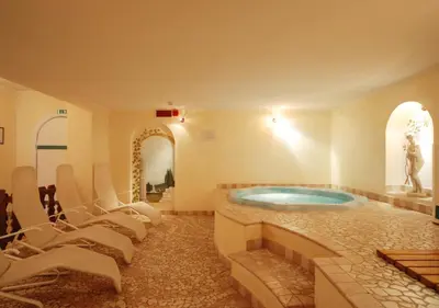 a lobby with a staircase with a table and a vase at Park Hotel Villa Trunka Lunka in Cavalese