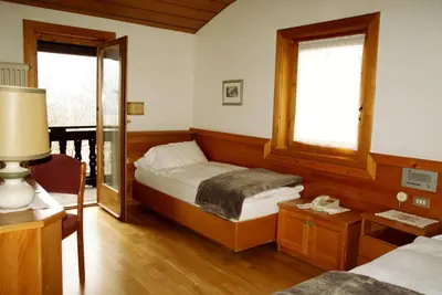 a bedroom with a large bed in a wooden room at Park Hotel Villa Trunka Lunka in Cavalese