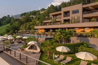 an aerial view of a hotel with a pool and umbrellas at Hotel Panorama in Schenna