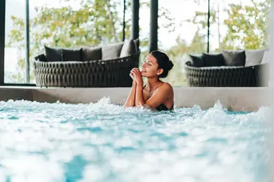 a woman sitting in a pool of water at Hotel Panorama in Schenna