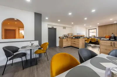 a restaurant with yellow chairs and tables in a room at Kyrr Smart Mountain Retreat in Moena