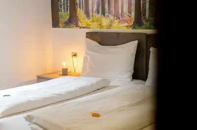 a bed with white sheets and a painting on the wall at Kyrr Smart Mountain Retreat in Moena