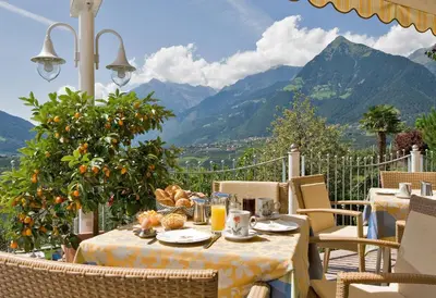 a table with oranges on it with a view of mountains at Hotel Garni Nachtigall in Schenna