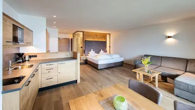 a kitchen and living room with a couch and a bed at Hotel Garni Nachtigall in Schenna