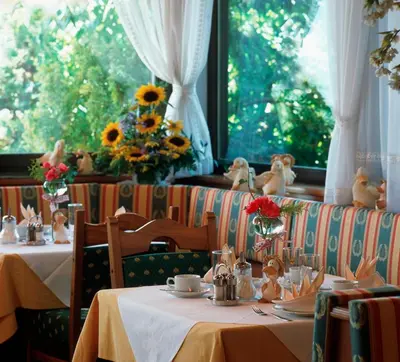 a dining room with two tables and a window at Hotel Garni Nachtigall in Schenna