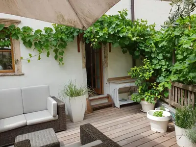 an outdoor patio with a couch and plants at Hof Am Bach in Caldaro