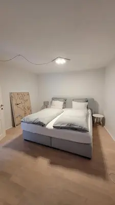 a bedroom with a bed in a white room at Hof Am Bach in Caldaro
