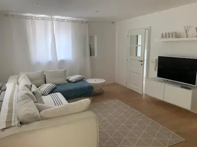 a living room with a couch and a flat screen tv at Hof Am Bach in Caldaro