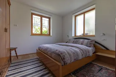 a bedroom with a bed and two windows at On the River in Laives