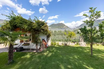 a house with a green yard with a fence at On the River in Laives