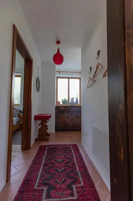 a hallway with a rug on the floor and a window at On the River in Laives