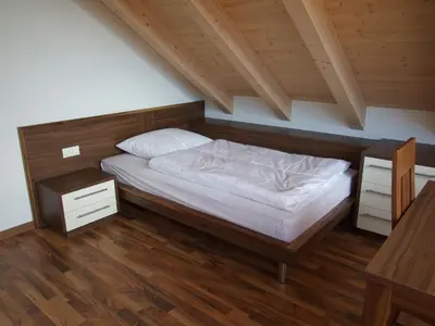 a bedroom with a bed and a wooden floor at Apartments Tauberhof in Naz-Sciaves