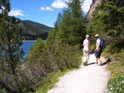 two people standing on a dirt path next to a lake at Apartments Tauberhof in Naz-Sciaves