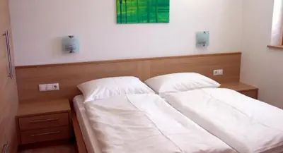 a bed with two white pillows in a bedroom at Apartments Tauberhof in Naz-Sciaves