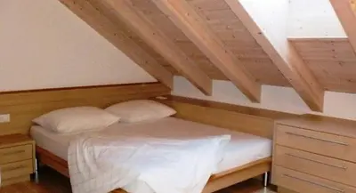 a bed with two pillows in a room at Apartments Tauberhof in Naz-Sciaves