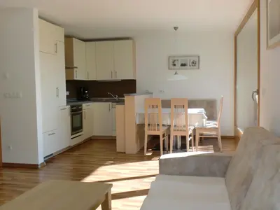 a kitchen and dining room with a table and chairs at Apartments Tauberhof in Naz-Sciaves