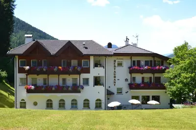 a large building with flowers on the balconies at Hotel Scoiattolo in Selva di Val Gardena