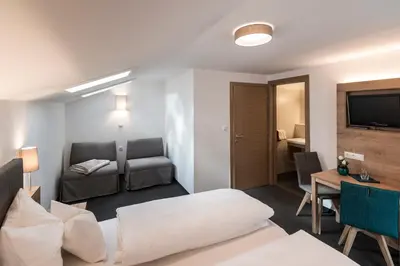 a living room with a couch and a table and a television at Garni Grünau in San Martino