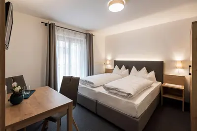 a hotel room with a bed and a table at Garni Grünau in San Martino