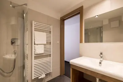 a bathroom with a sink and a shower and a mirror at Garni Grünau in San Martino