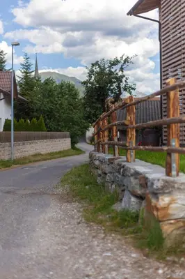 a stone fence next to a road next to a house at Tschafingerhof in Vipiteno