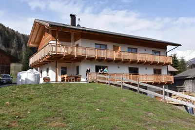 a house with a balcony on a hill at Tschafingerhof in Vipiteno