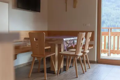 a dining room table with four chairs around it at Tschafingerhof in Vipiteno