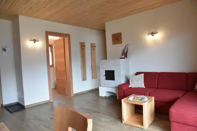 a living room with a red couch and a fireplace at Tschafingerhof in Vipiteno