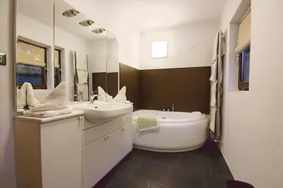 a bathroom with a sink and a tub and a mirror at Finhäusl in Aldino