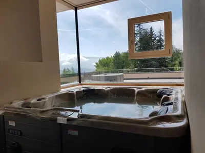 a bath tub in a room with a window at Aparthotel Malga in Caldaro