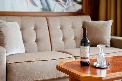 a bottle of wine on a table next to a couch at Hotel Nocturnes in Naturno