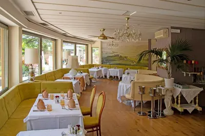 a restaurant with tables and chairs and a chandelier at Hotel Nocturnes in Naturno