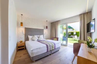 a bedroom with a bed and a table and a desk at Hotel Mehrhauser in Nalles